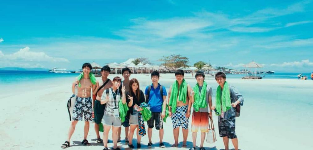 真っ白なビーチで写真を撮っている埼玉工業大学の学生を含む日本人留学生達