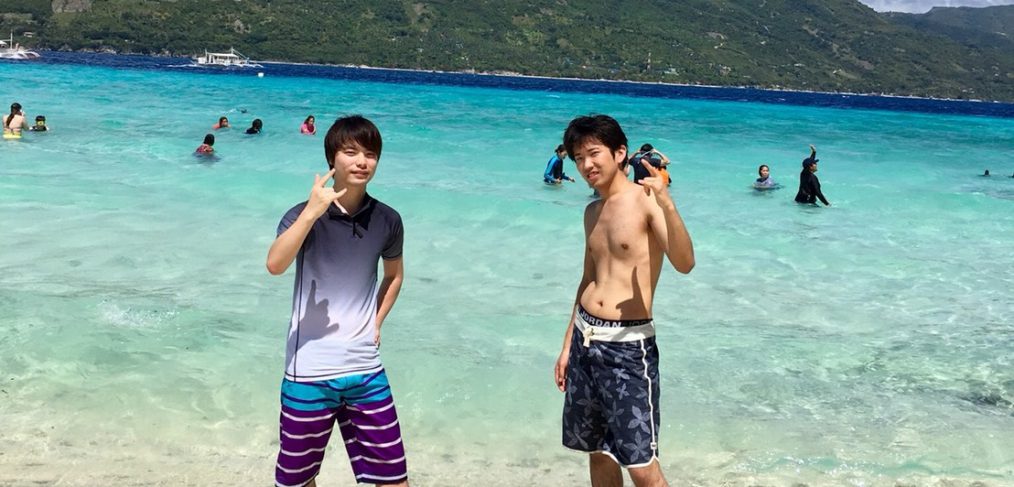 海で記念撮影をする2人の日本人留学生